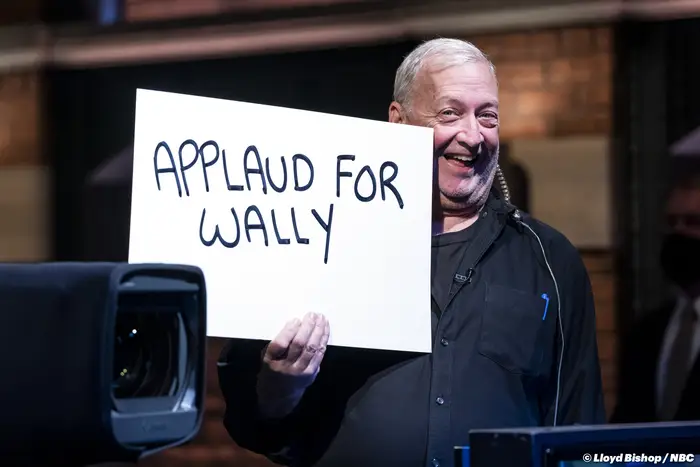 A man holds up a cue card.